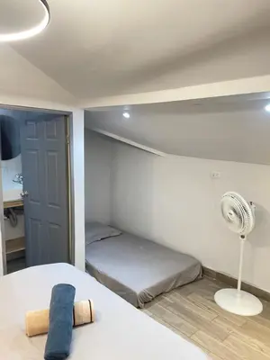 a small bedroom with a bed and a fan at Sage house de 2 alcoba la 70 laurles estadio in Medellín