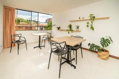 a dining room with a table and chairs and a window at Tu Refugio Acogedor en el corazón de Medellín Hab Privada A in Medellín