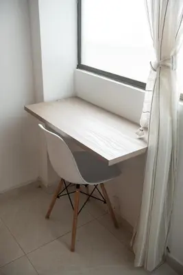 a desk in a room with a chair and a window at Alojamiento en el corazón de Medellín Hab Privada B in Medellín