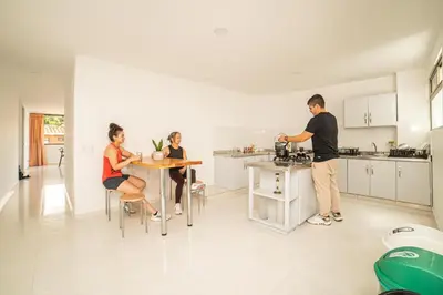 a group of people sitting at a table in a kitchen at Alojamiento en el corazón de Medellín Hab Privada B in Medellín