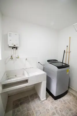 a white bathroom with a sink and a trash can at Alojamiento en el corazón de Medellín Hab Privada B in Medellín