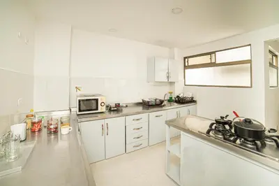 a kitchen with white cabinets and a counter top at Alojamiento en el corazón de Medellín Hab Privada B in Medellín