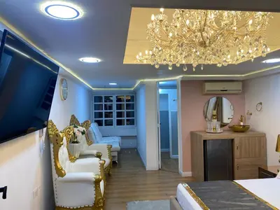 a bedroom with a chandelier and a living room at Nuevo y lujoso apartamento por el lleras (en el poblado ) in Medellín